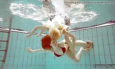 Two Cute Babes Enjoy a Nude Swim in the Pool