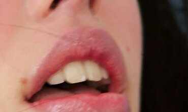 Bony dark-haired with large bee-stung lips, pummels herself rock-hard with massager and fake penis on sofa.