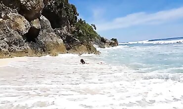 Solo Female Pees on Tropical Beach Rock