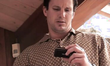 Curly haired fellow globs his trousers and jerks his pecker while witnessing pornography on his smartphone.