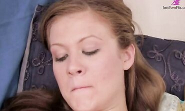 Horny brunette in short black dress talks to and entices viewer as she gets herself off in bed with vibrators and dildos.
