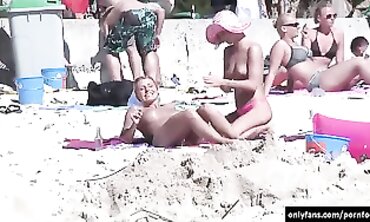 Secret camera while femmes sunbathing bare on the beach